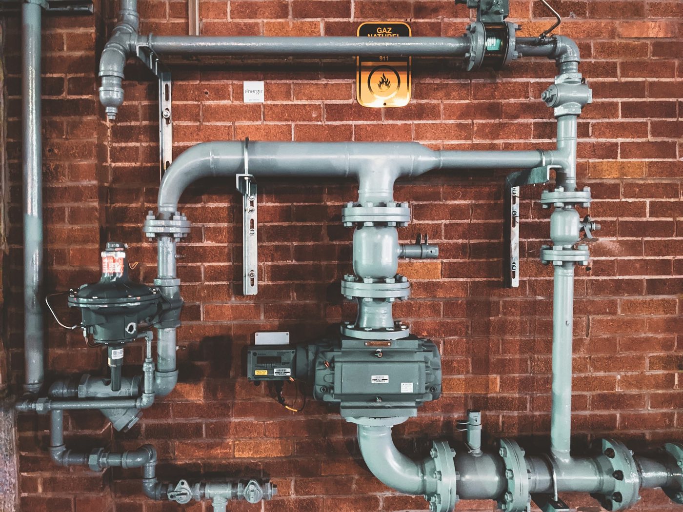 Pipe fittings and valves mounted on a brick wall
